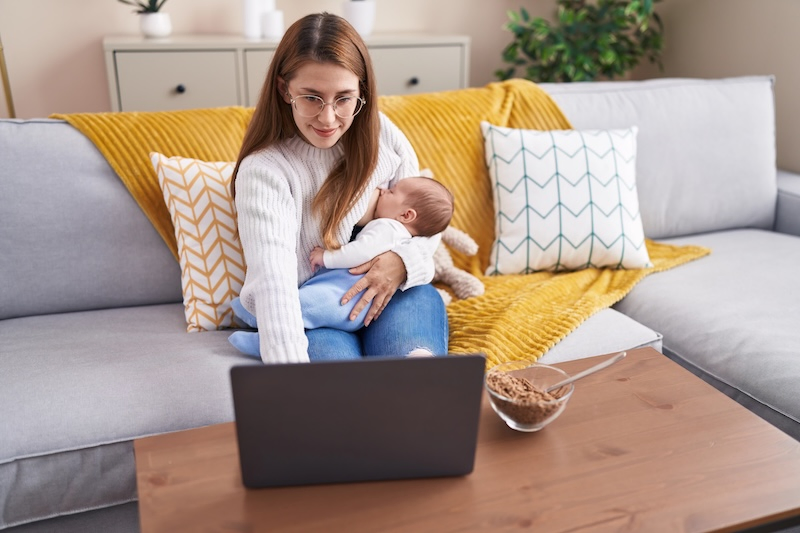 Mother breastfeeding her child during an online consultation